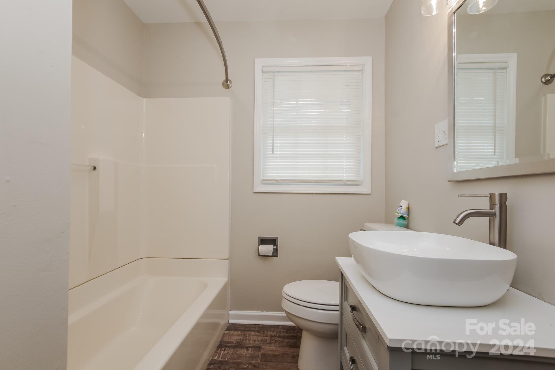 123 Boatright Road Pineville, NC 28134 - Photo 11 of 15 a bathroom with a granite countertop sink a toilet and bathtub