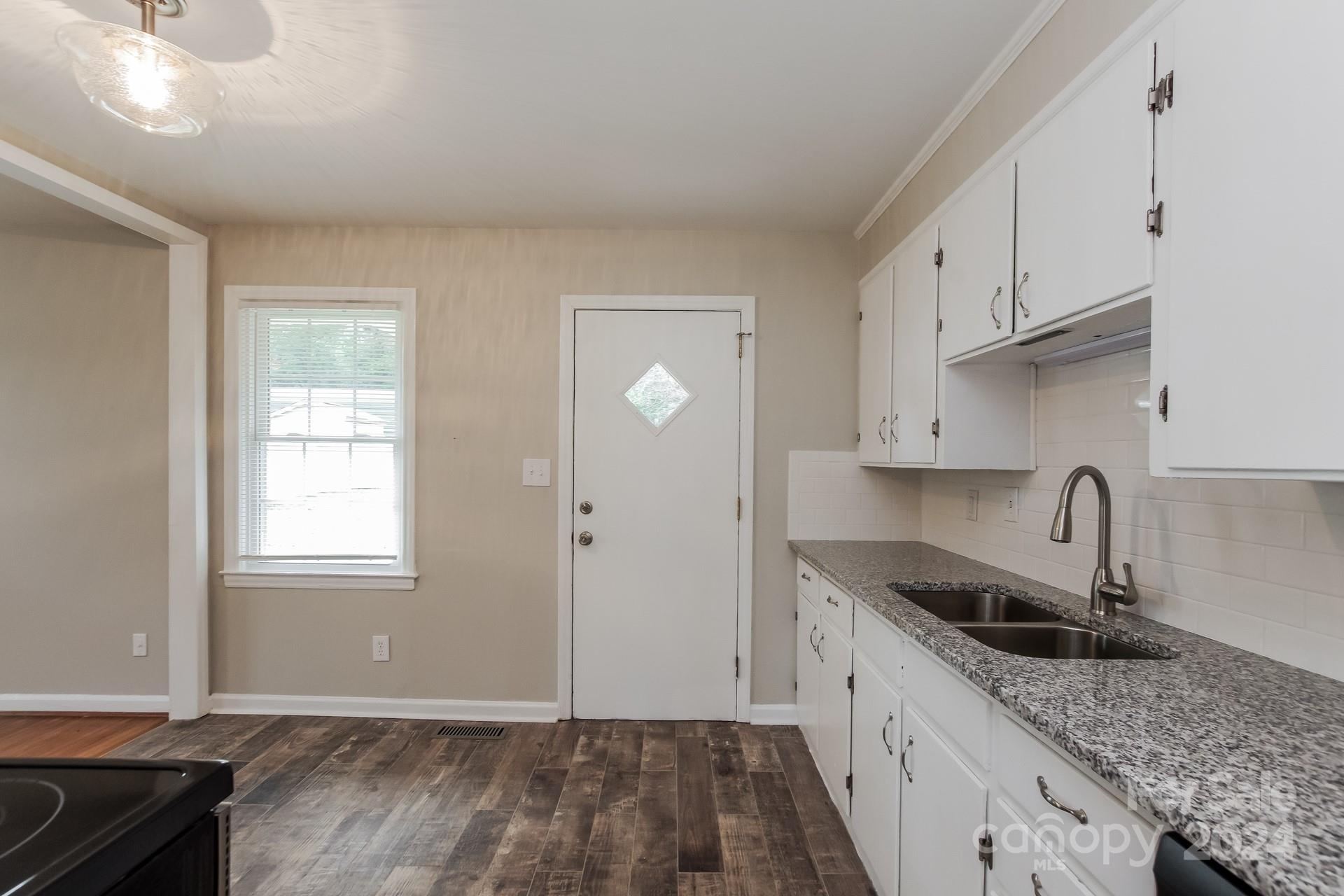 123 Boatright Road Pineville, NC 28134 - Photo 7 of 15 a kitchen with granite countertop a sink a stove and cabinets