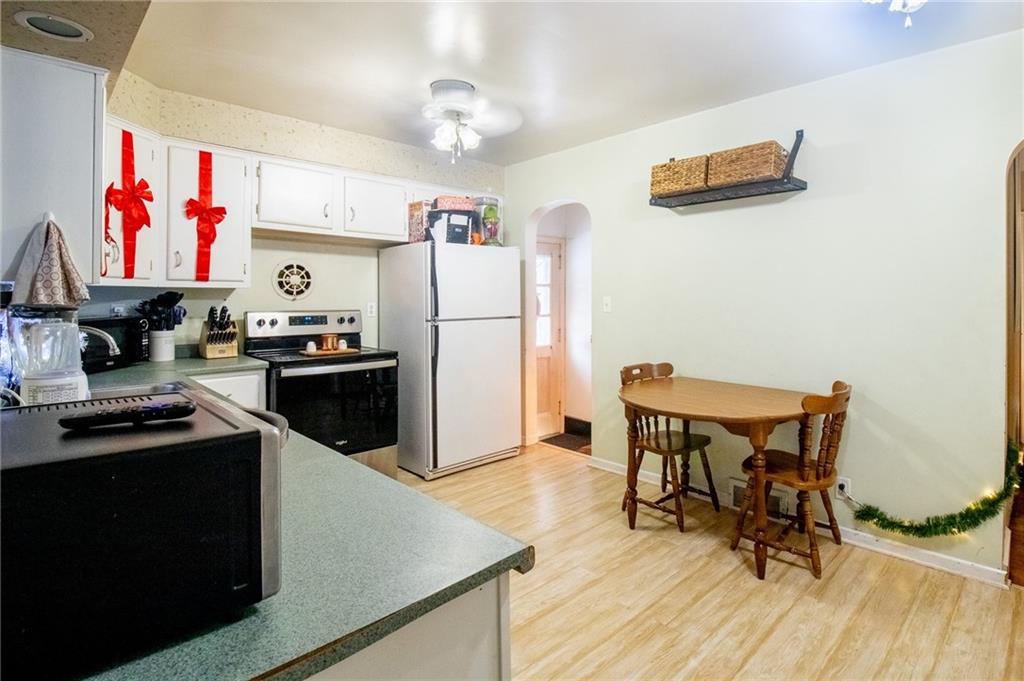 125 Slate Run Road Greensburg, PA 15601 - Photo 8 of 37 a kitchen with stainless steel appliances a stove a refrigerator and a dining table with wooden floor