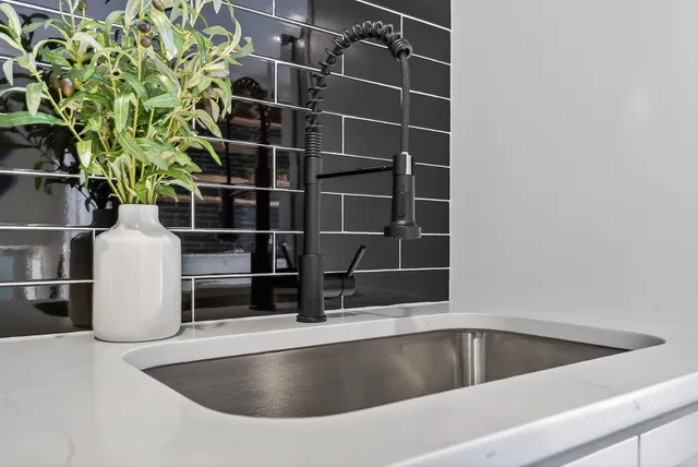 a view of a kitchen with a sink oven cabinets and staircase