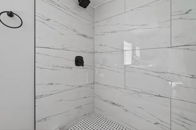 a bathroom with a granite countertop bathtub shower sink vanity and toilet