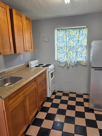 a kitchen with a sink a stove a refrigerator and a window