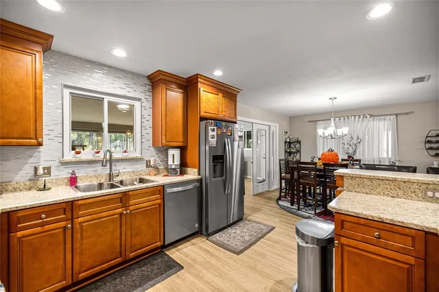 a kitchen with stainless steel appliances granite countertop a sink stove and refrigerator