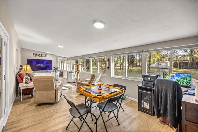 a living room with furniture a flat screen tv and a floor to ceiling window