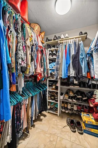 a view of walk in closet with clothes