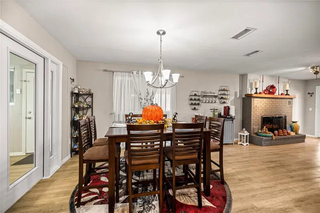 a dining room filled chandelier and wooden floor