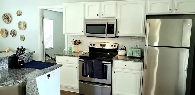 a kitchen with stainless steel appliances granite countertop a refrigerator stove and sink