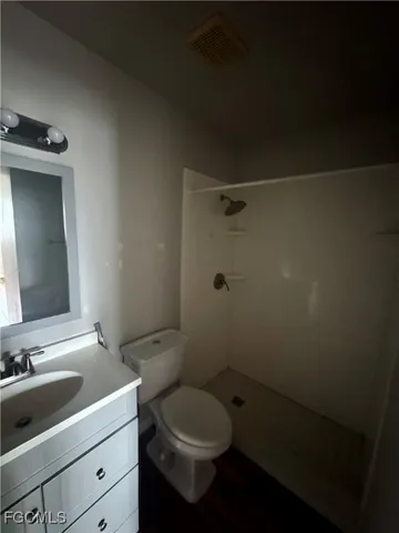 a bathroom with a toilet sink vanity and shower