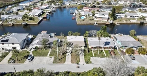 an aerial view of residential houses with outdoor space and lake view