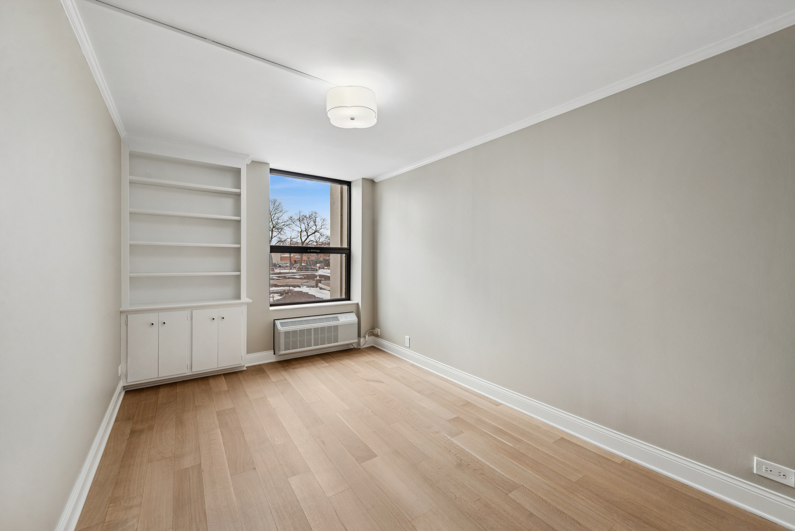 1500 Sheridan Road, Unit 1K Wilmette, IL 60091 - Photo 17 of 25 a view of an empty room with a window and wooden floor