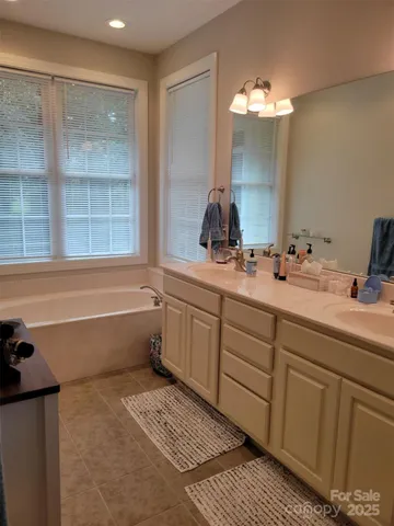 a bathroom with a tub sink and mirror