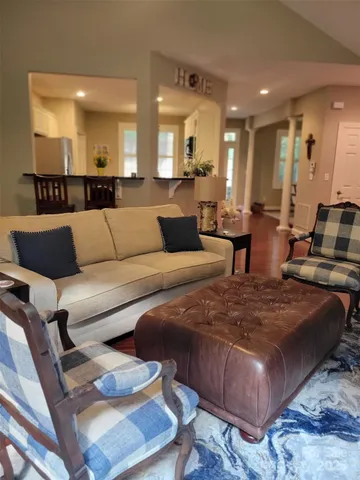 a living room with furniture and a view of kitchen