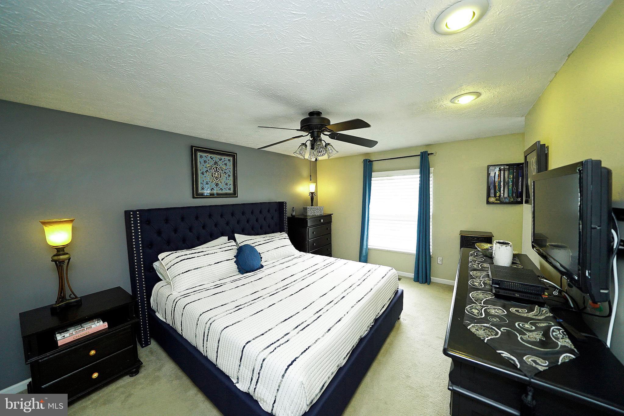 4424 Cub Run Road Chantilly, VA 20151 - Photo 21 of 30 a bedroom with a bed and a flat tv screen on a dresser
