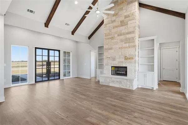 an empty room with wooden floor and fireplace
