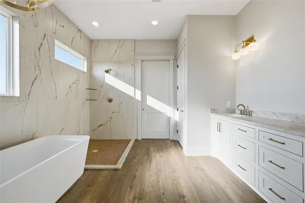 a bathroom with a tub sink and mirror