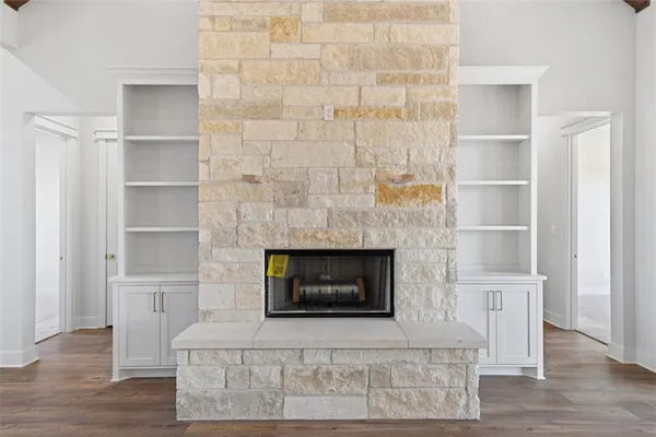 a living room with a fireplace and a walk in closet with wooden floor