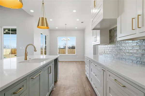 an open kitchen with stainless steel appliances granite countertop a sink a stove and a wooden floors