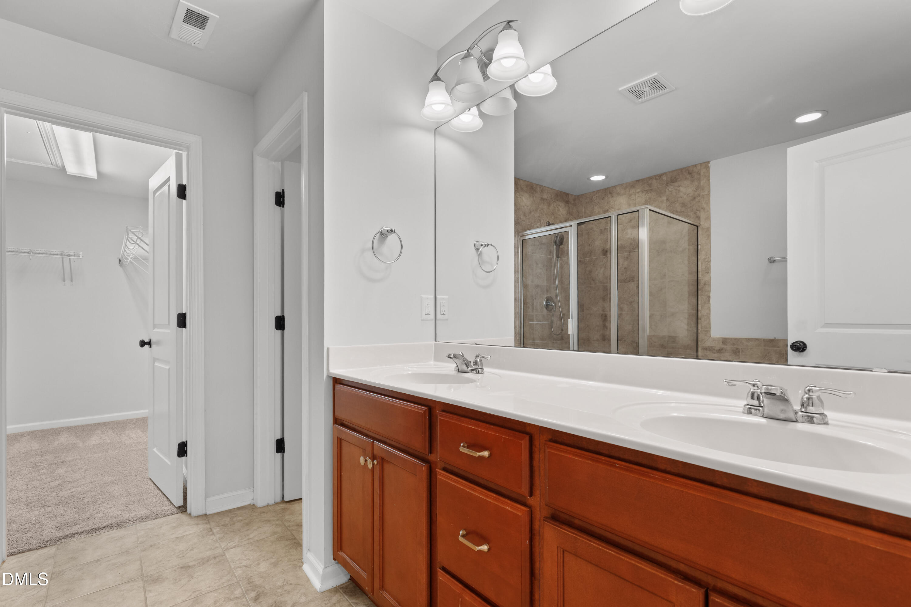 1109 Laurel Twist Road Cary, NC 27513 - Photo 23 of 37 a spacious bathroom with a granite countertop sink a mirror and a shower
