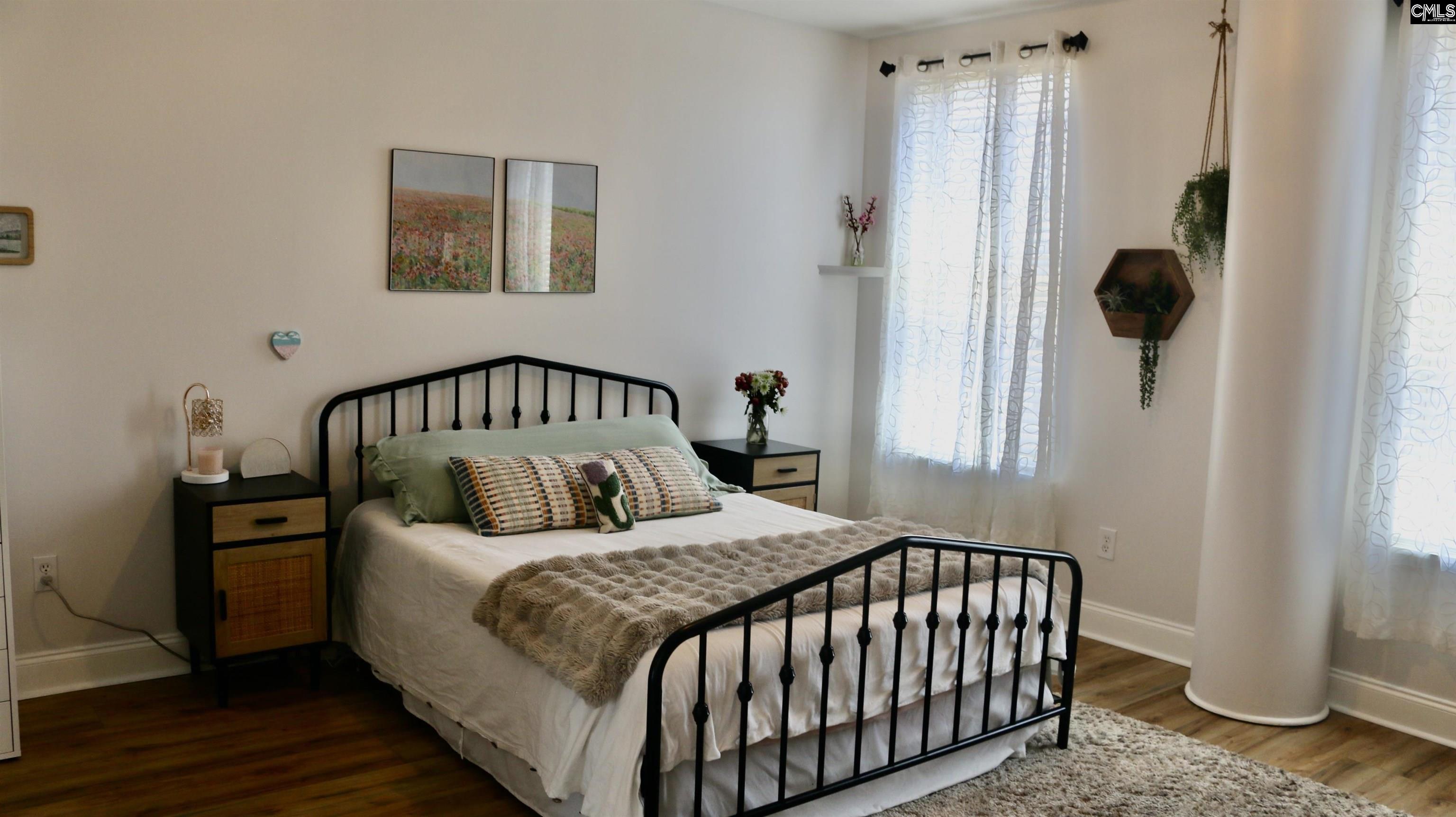 601 Main Street, Unit 323 Columbia, SC 29201 - Photo 31 of 68 a bedroom with a bed and wooden floor