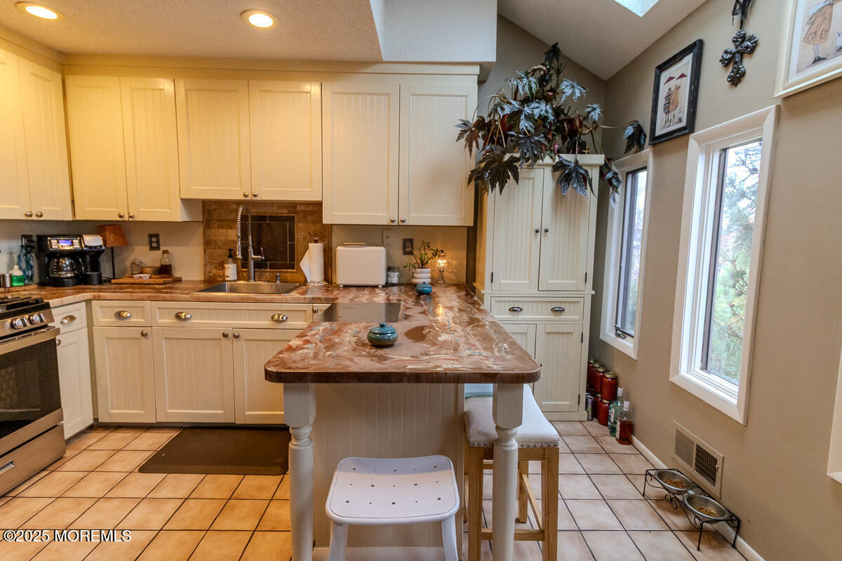 8 Hidden Harbor Drive Point Pleasant, NJ 08742 - Photo 12 of 32 a kitchen with stainless steel appliances kitchen island granite countertop a sink a counter top space and cabinets