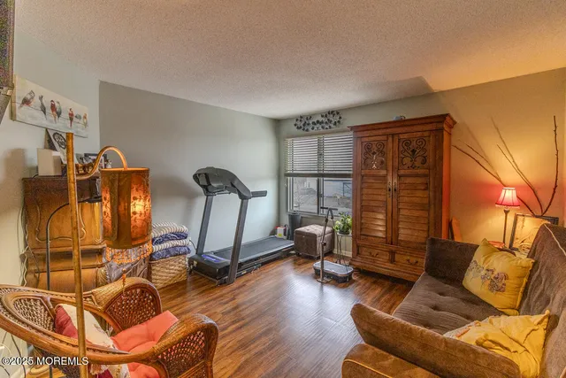 a living room with furniture a flat screen tv and gym equipment
