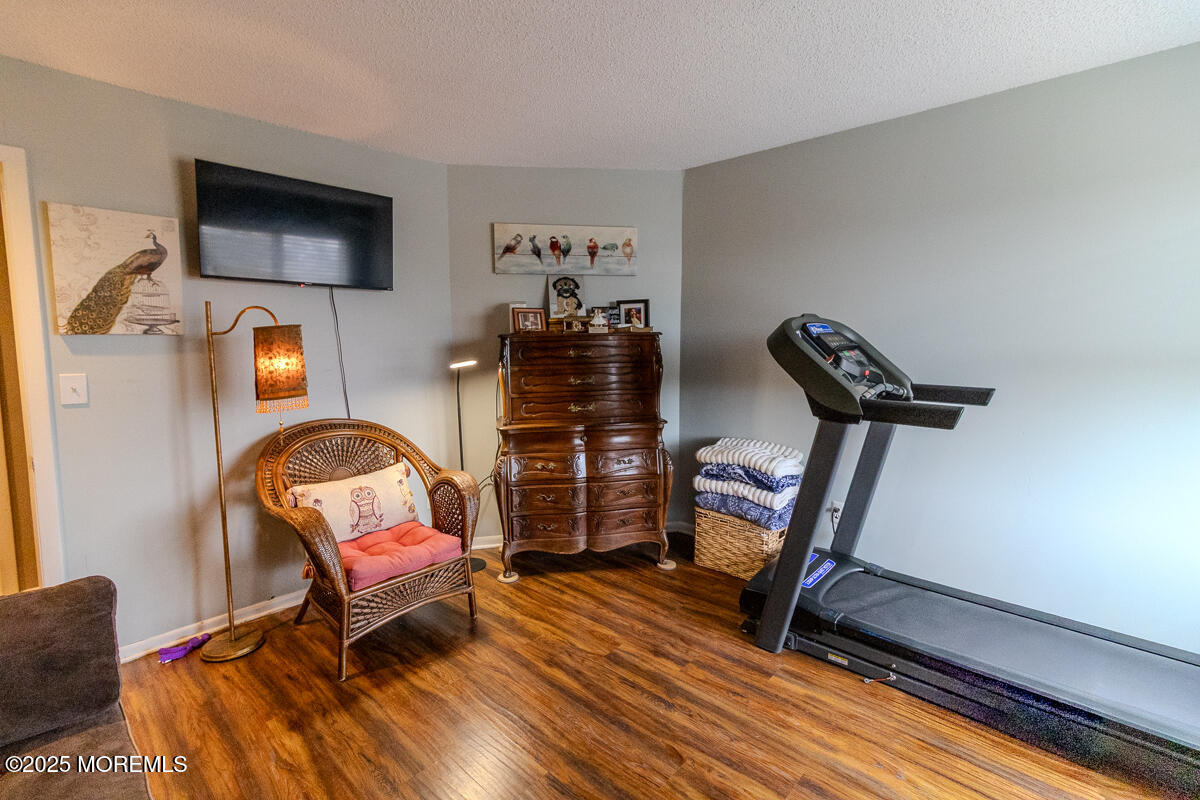 8 Hidden Harbor Drive Point Pleasant, NJ 08742 - Photo 20 of 32 a living room with furniture a flat screen tv and gym equipment