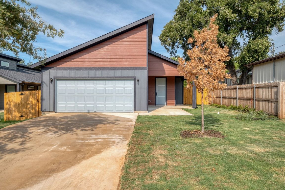 View of front of property featuring driveway, a porch, and a garage