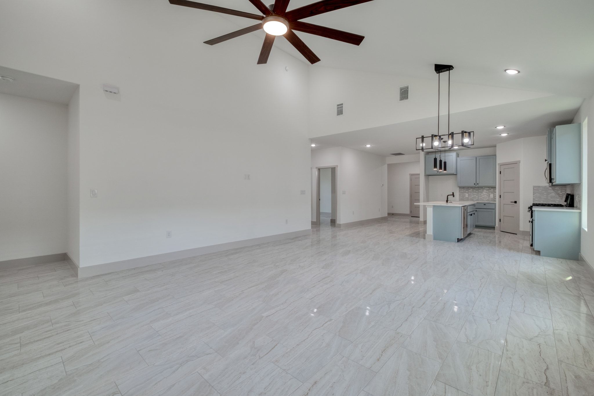 202 Washington Street Elgin, TX 78621 - Photo 11 of 26 Unfurnished living room featuring ceiling fan and high vaulted ceiling