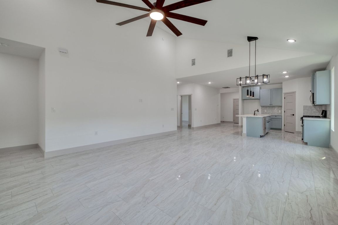 202 Washington Street Elgin, TX 78621 - Photo 11 of 26 Unfurnished living room featuring ceiling fan and high vaulted ceiling