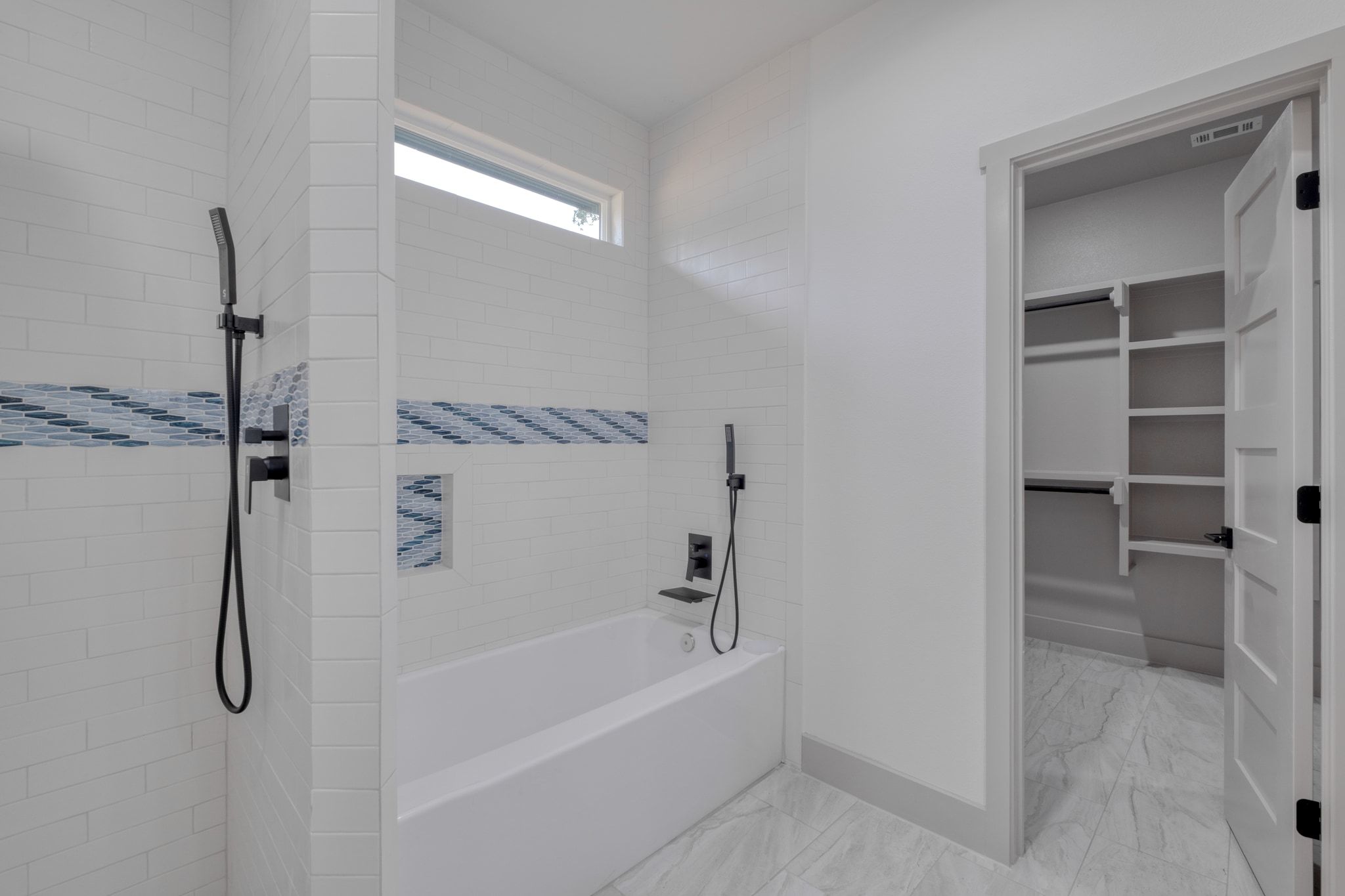 202 Washington Street Elgin, TX 78621 - Photo 15 of 26 Full bath featuring tiled shower, a garden tub, a walk in closet, and light marble finish flooring