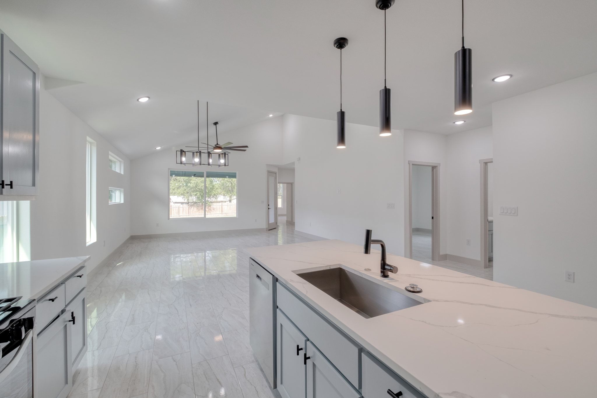 202 Washington Street Elgin, TX 78621 - Photo 8 of 26 Kitchen featuring hanging light fixtures, light marble finish flooring, recessed lighting, light stone counters, and ceiling fan