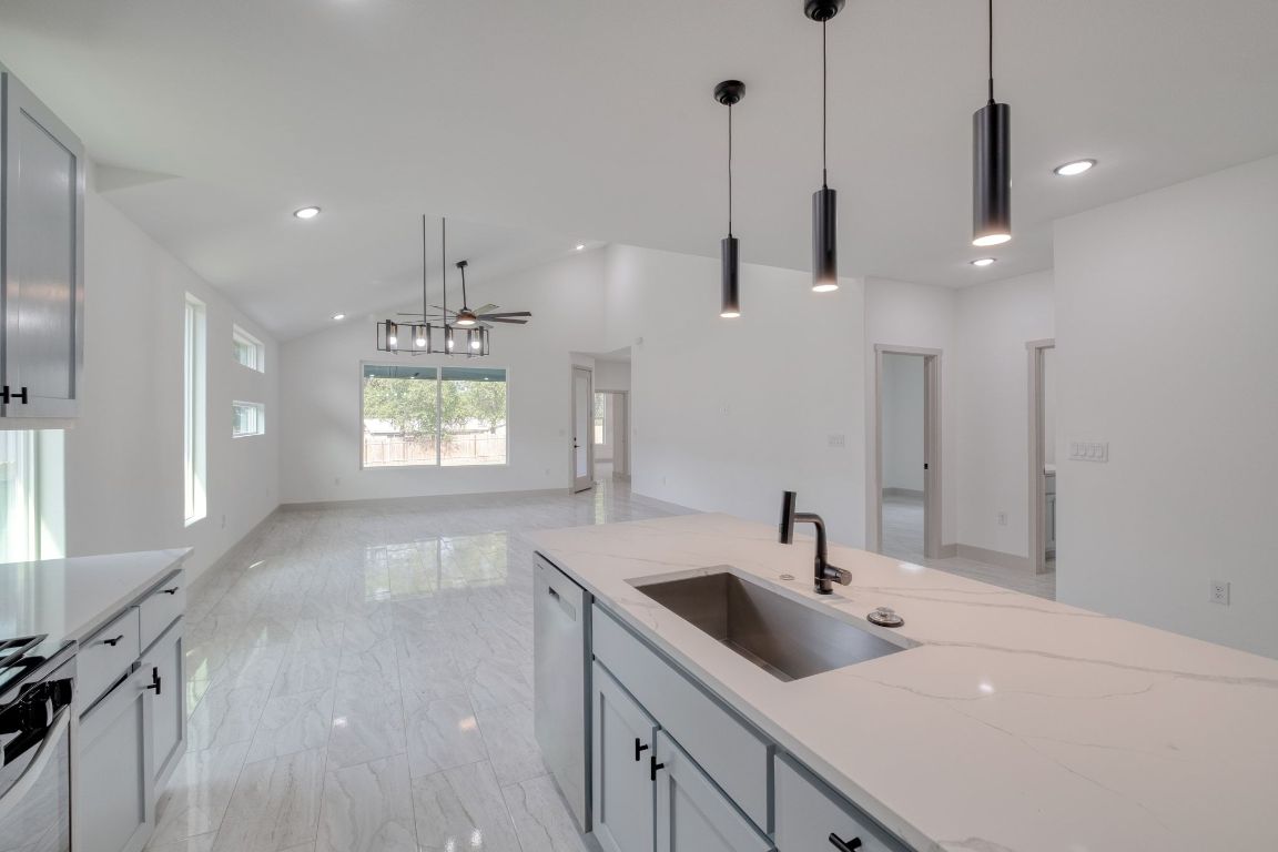 202 Washington Street Elgin, TX 78621 - Photo 8 of 26 Kitchen featuring hanging light fixtures, light marble finish flooring, recessed lighting, light stone counters, and ceiling fan