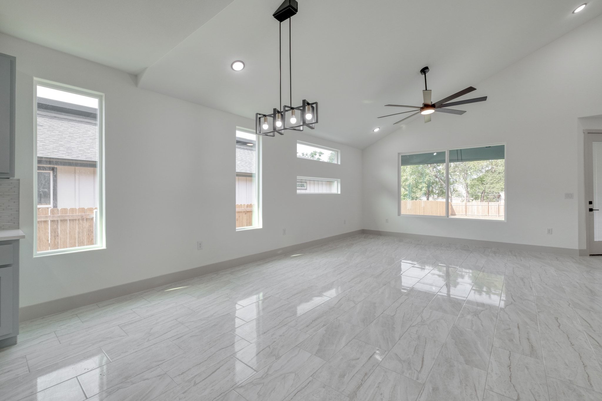 202 Washington Street Elgin, TX 78621 - Photo 9 of 26 Dinning area with healthy amount of natural light, high vaulted ceiling, recessed lighting, ceiling fan, and light marble finish floors