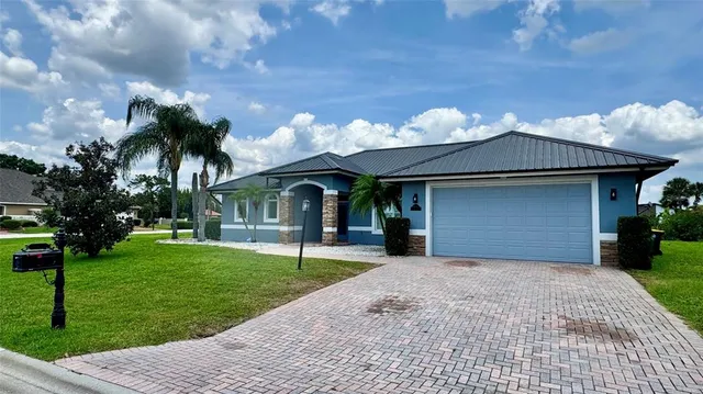 a front view of a house with a garden and trees
