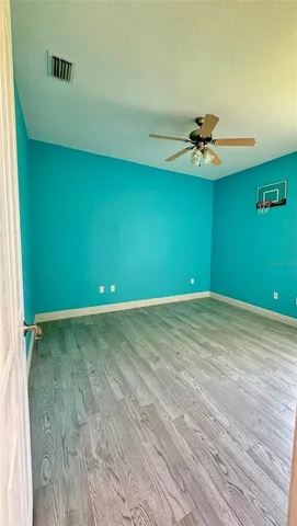 a view of a room with a ceiling fan and a fan