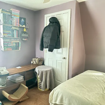 a bedroom with a bed and a painting on the wall