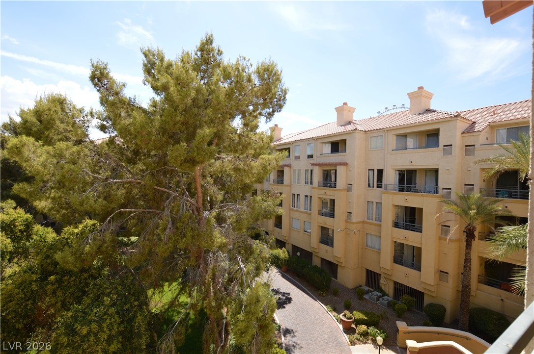 230 East Flamingo Road, Unit 334 Las Vegas, NV 89169 - Photo 20 of 37 Mature trees frame the multi-level stucco architecture of this elegant residential building.
