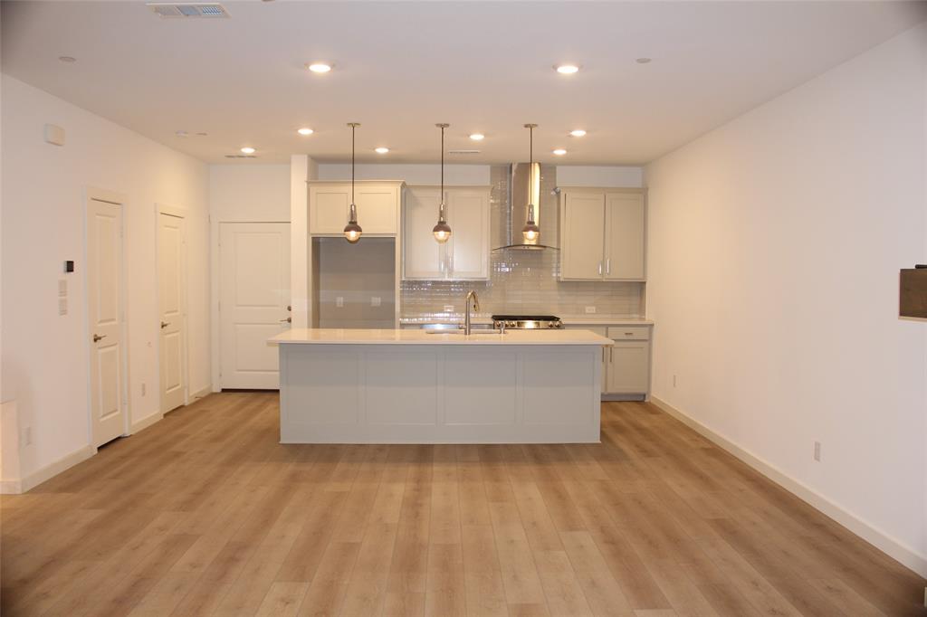 a view of kitchen with kitchen island white cabinets and stainless steel appliances