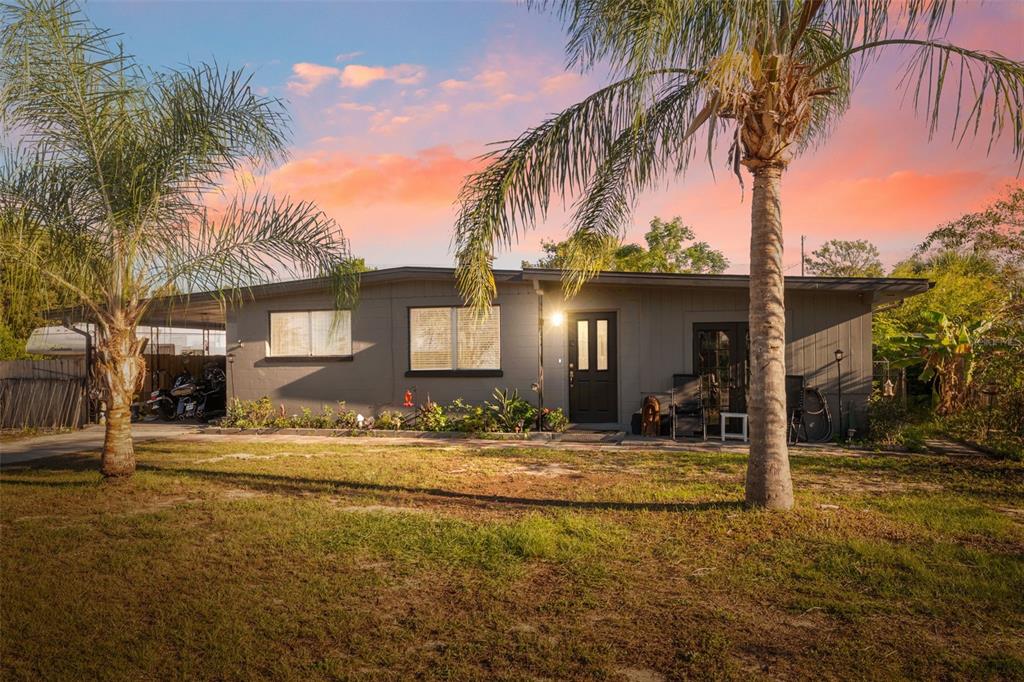 a view of a house with small yard and palm trees