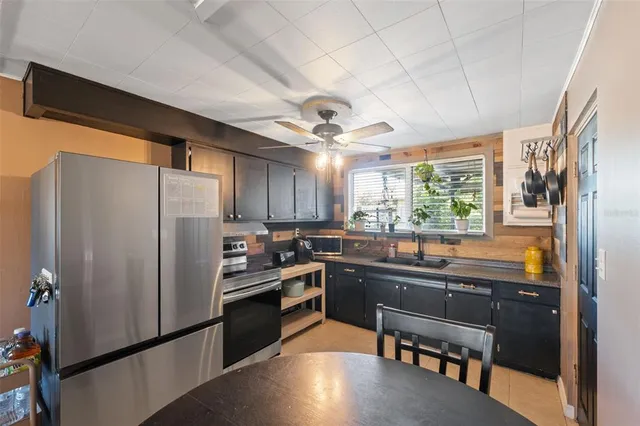 a kitchen with stainless steel appliances granite countertop a refrigerator a sink dishwasher a stove and white countertops with wooden floor