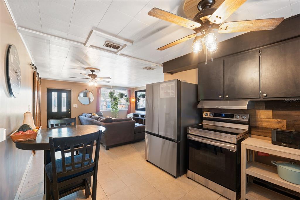 7002 Eisenhower Street Weeki Wachee, FL 34613 - Photo 6 of 65 a kitchen with refrigerator a stove and furniture
