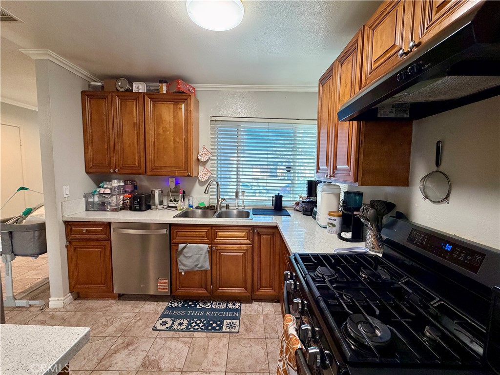 321 Red Cedar Place Perris, CA 92570 - Photo 7 of 21 a kitchen with granite countertop a stove a sink dishwasher and cabinets