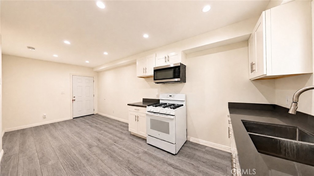 6851 Foothill Boulevard Tujunga, CA 91042 - Photo 37 of 50 a kitchen with a sink a microwave and cabinets