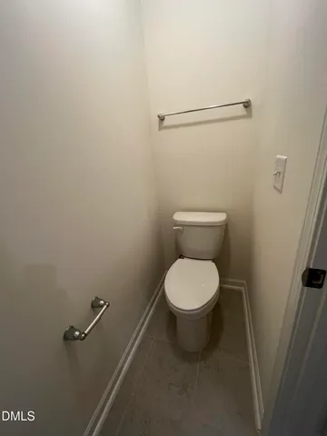 a white toilet sitting next to a shower
