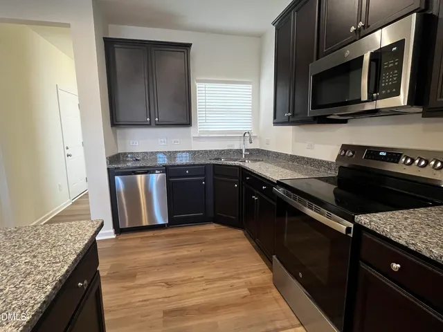 a kitchen with a sink stove and microwave