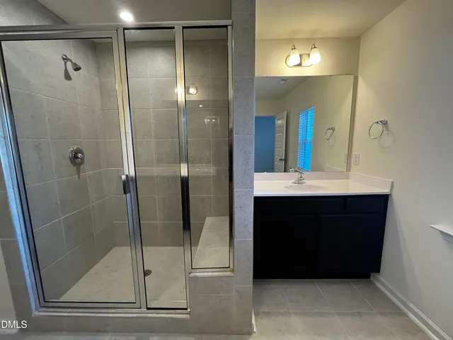 a bathroom with a sink a mirror and shower