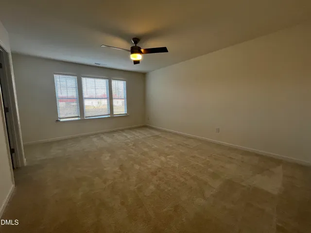 an empty room with windows and fan view