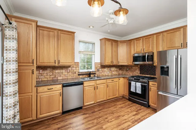 a kitchen with stainless steel appliances granite countertop a stove and a refrigerator