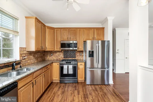 a kitchen with stainless steel appliances a refrigerator sink and microwave