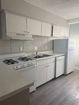 a kitchen with cabinets appliances and wooden floor